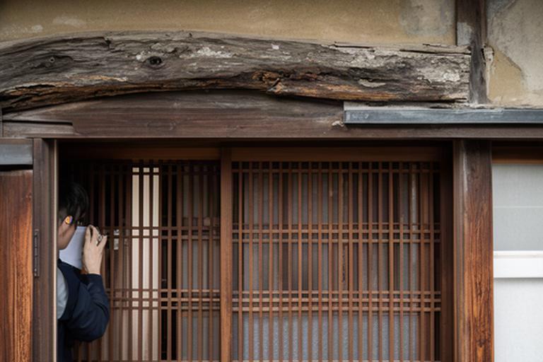 京都の町家で改修前の格子戸と古い木梁を確認する現場